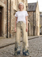 Woman in cream-beige tie-dye ombre wide-leg trousers standing on a cobblestone street