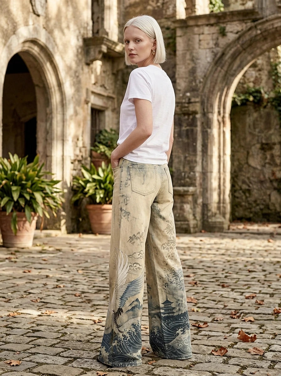 Woman in cream-beige tie-dye ombre wide-leg trousers standing in a stone courtyard