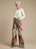 Woman wearing brown vintage chic high-waisted patterned trousers, studio setting