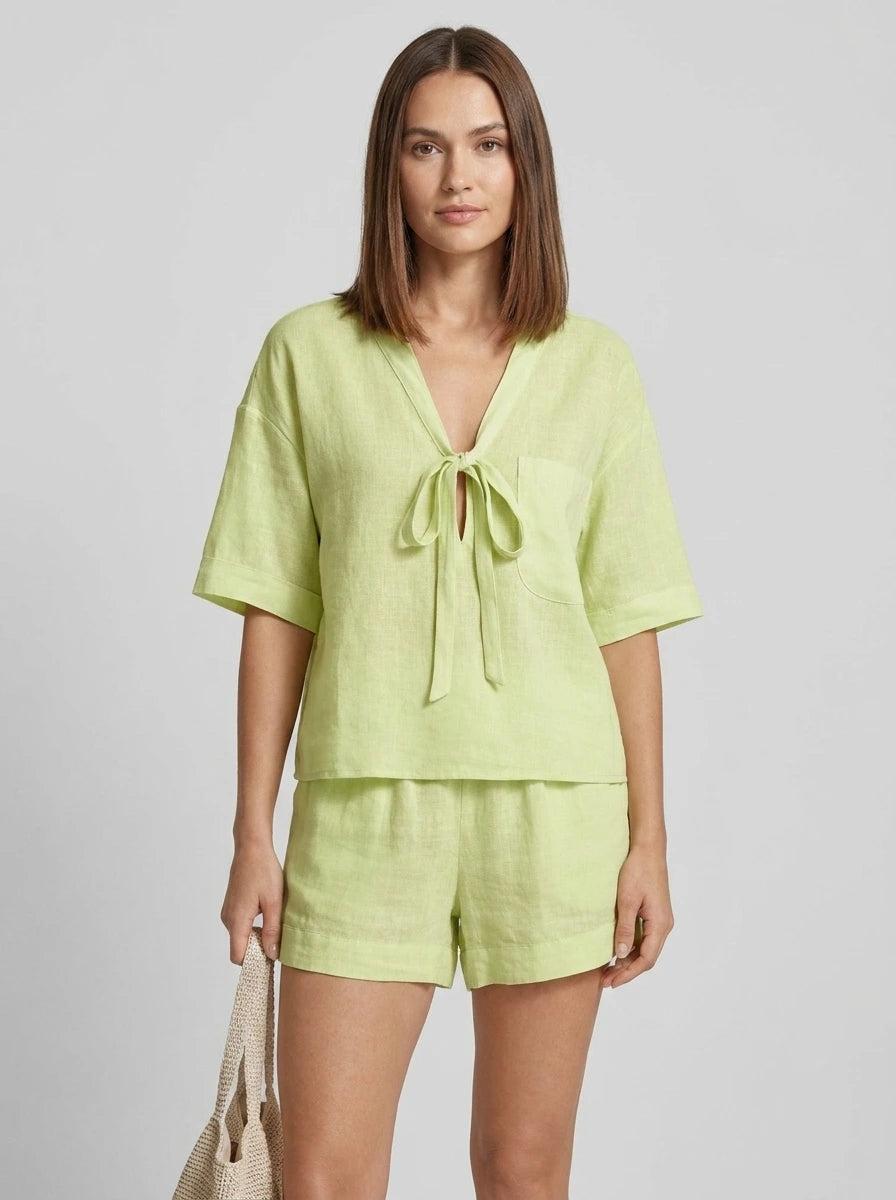 Woman wearing a green casual two-piece set with short collar in a studio setting