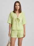 Woman wearing a green casual two-piece set with short collar in a studio setting
