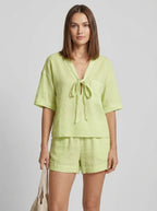 Woman wearing a green casual two-piece set with short collar in a studio setting