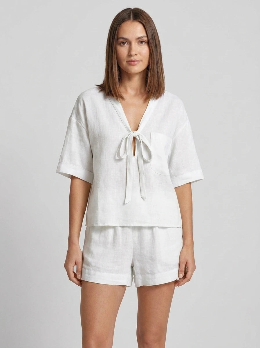 Woman wearing a white casual two-piece set with short collar in a studio setting