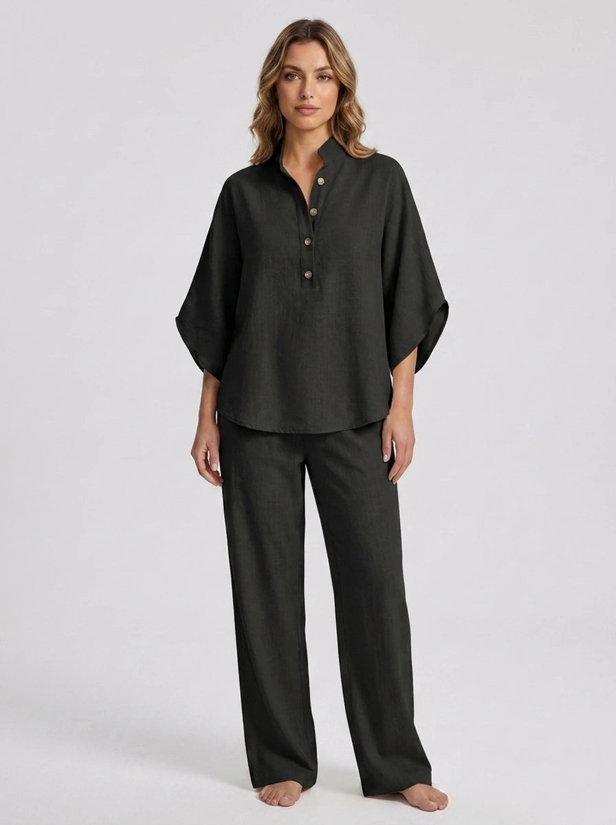 Woman wearing a black linen-style two-piece set, relaxed button-front top and wide-leg trousers, studio shot