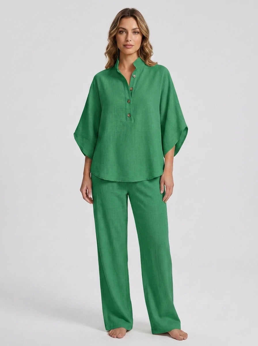 Woman wearing a green linen-style two-piece set, relaxed button-front top and wide-leg trousers, studio shot