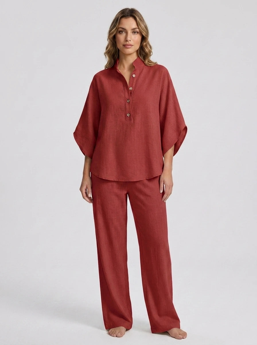 Woman wearing a red linen-style two-piece set, relaxed button-front top and wide-leg trousers, studio shot