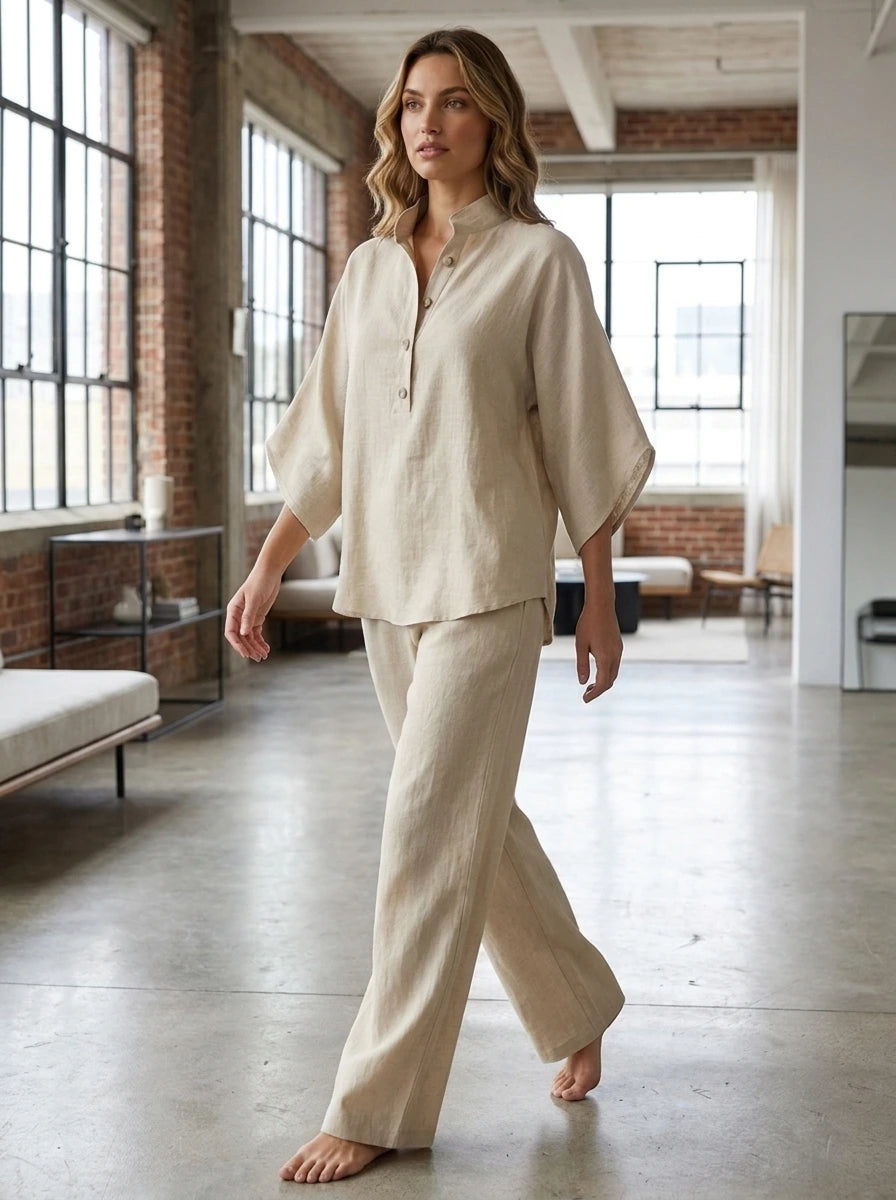 Woman wearing a sand beige linen-style two-piece set indoors, relaxed fit blouse and flowing trousers