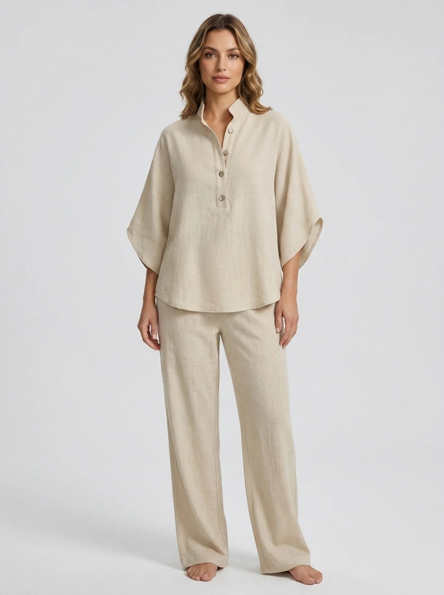 Woman wearing a sand beige linen-style two-piece set, relaxed button-front top and wide-leg trousers, studio shot