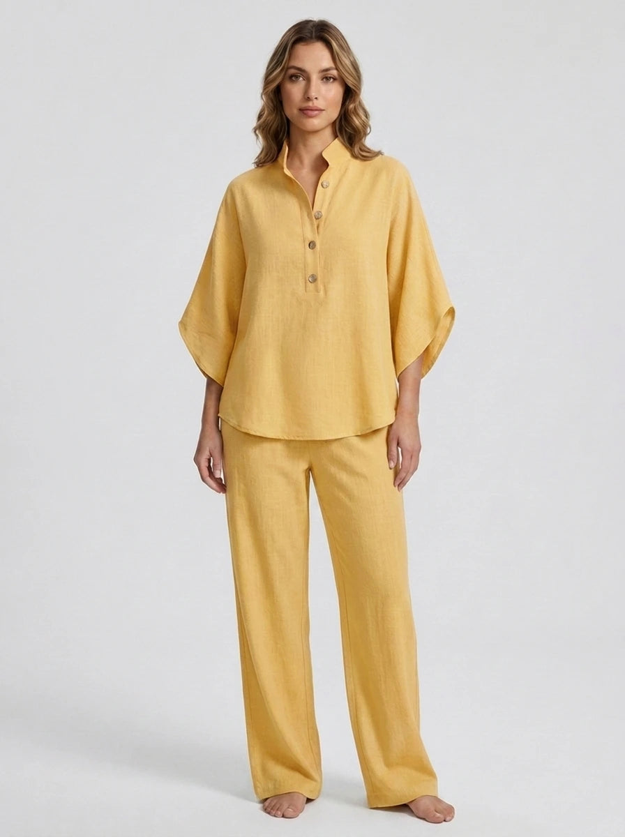 Woman wearing a yellow linen-style two-piece set, relaxed button-front top and wide-leg trousers, studio shot