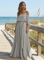 Woman wearing a taupe off-shoulder lightweight two-piece set on a beach boardwalk