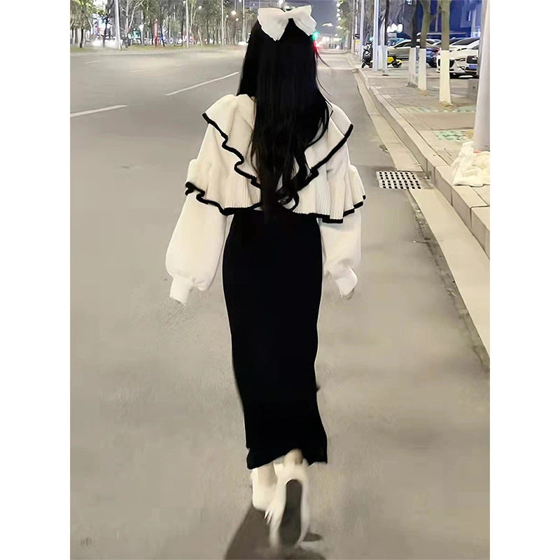 Back view of cream ruffle blouse and black fishtail skirt two-piece set