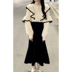 Woman wearing cream ruffle blouse with black fishtail skirt, full body view