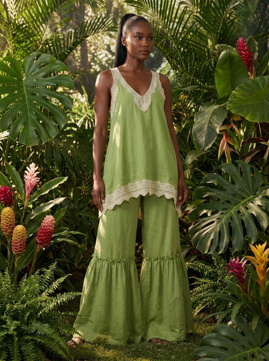 Woman wearing a green eyelash lace cami top and wide-leg pants two-piece set in a tropical garden