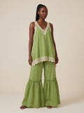 Woman wearing a green eyelash lace cami top and wide-leg pants two-piece set in a studio setting