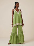 Woman wearing a green eyelash lace cami top and wide-leg pants two-piece set in a studio setting