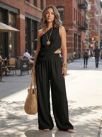 Woman wearing a black one-shoulder ruched cutout cami top and wide-leg pants two-piece set on a city street