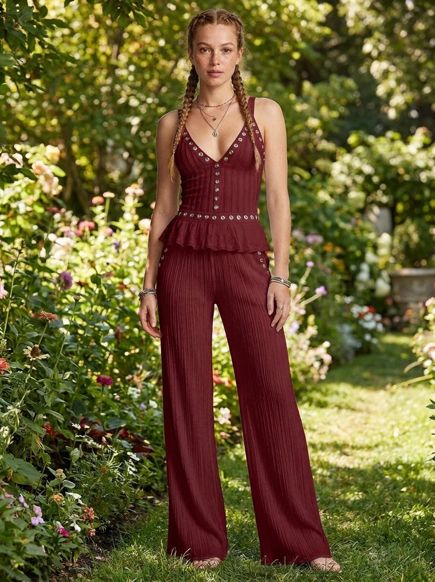 Woman wearing a burgundy ribbed cami crop top and matching wide-leg pants two-piece set in a lush garden