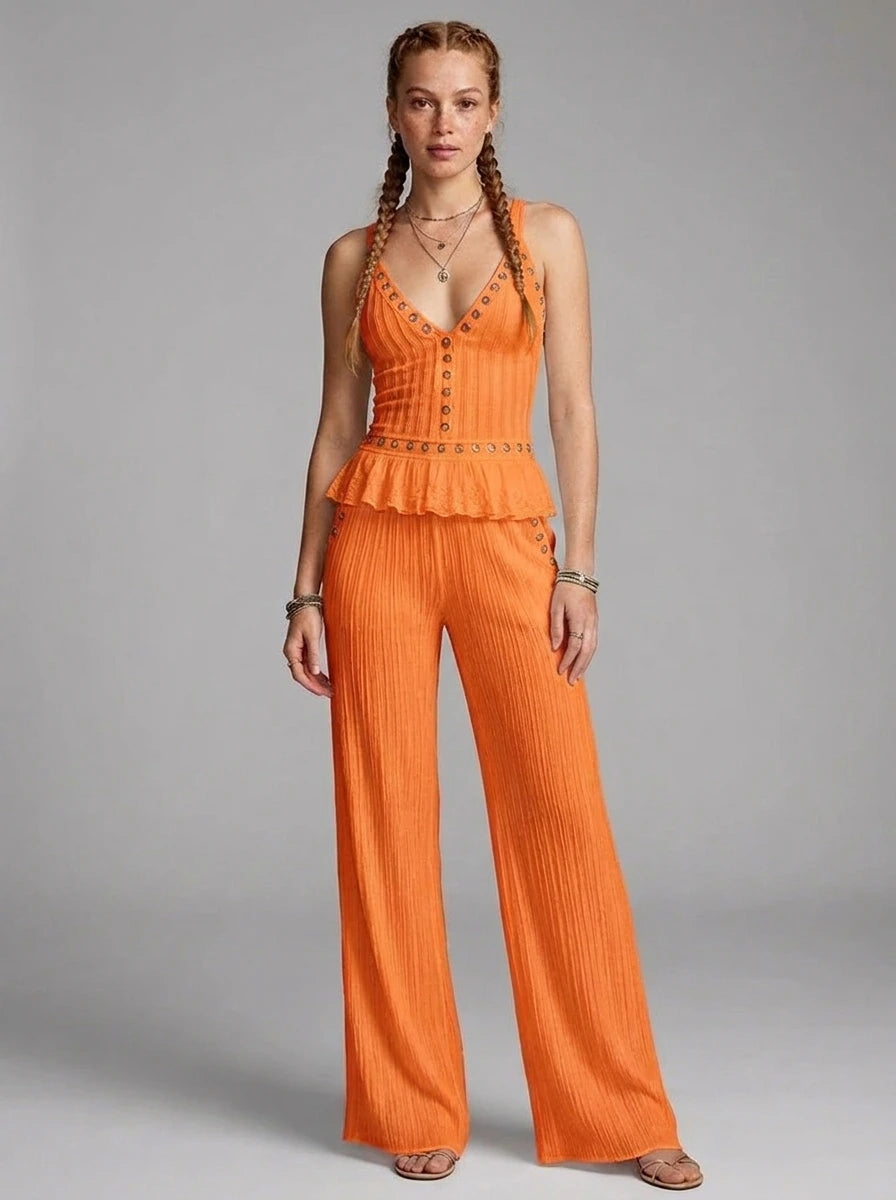 Woman wearing an orange ribbed cami crop top and matching wide-leg pants two-piece set in a studio setting