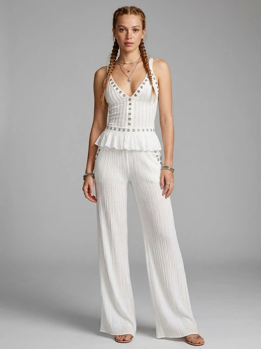Woman wearing a white ribbed cami crop top and matching wide-leg pants two-piece set in a studio setting