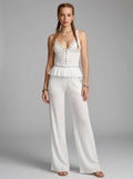 Woman wearing a white ribbed cami crop top and matching wide-leg pants two-piece set in a studio setting