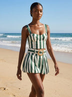 Woman wearing a green striped smocked tank top and bubble shorts two-piece set on a sunny beach