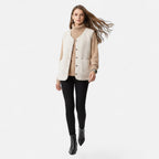 Woman wearing a beige plush sherpa vest over a sweater