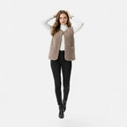 Woman wearing a light coffee taupe plush sherpa vest, lifestyle shot