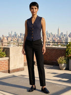 Woman wearing a navy vintage striped sleeveless vest on a rooftop terrace with city skyline