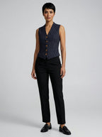 Woman wearing a navy vintage striped sleeveless vest in a studio setting