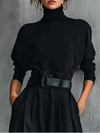Woman wearing a black belted two-piece bikini set in a lifestyle setting