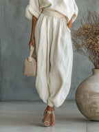 Woman wearing an off-white off-shoulder two-piece outfit, side view