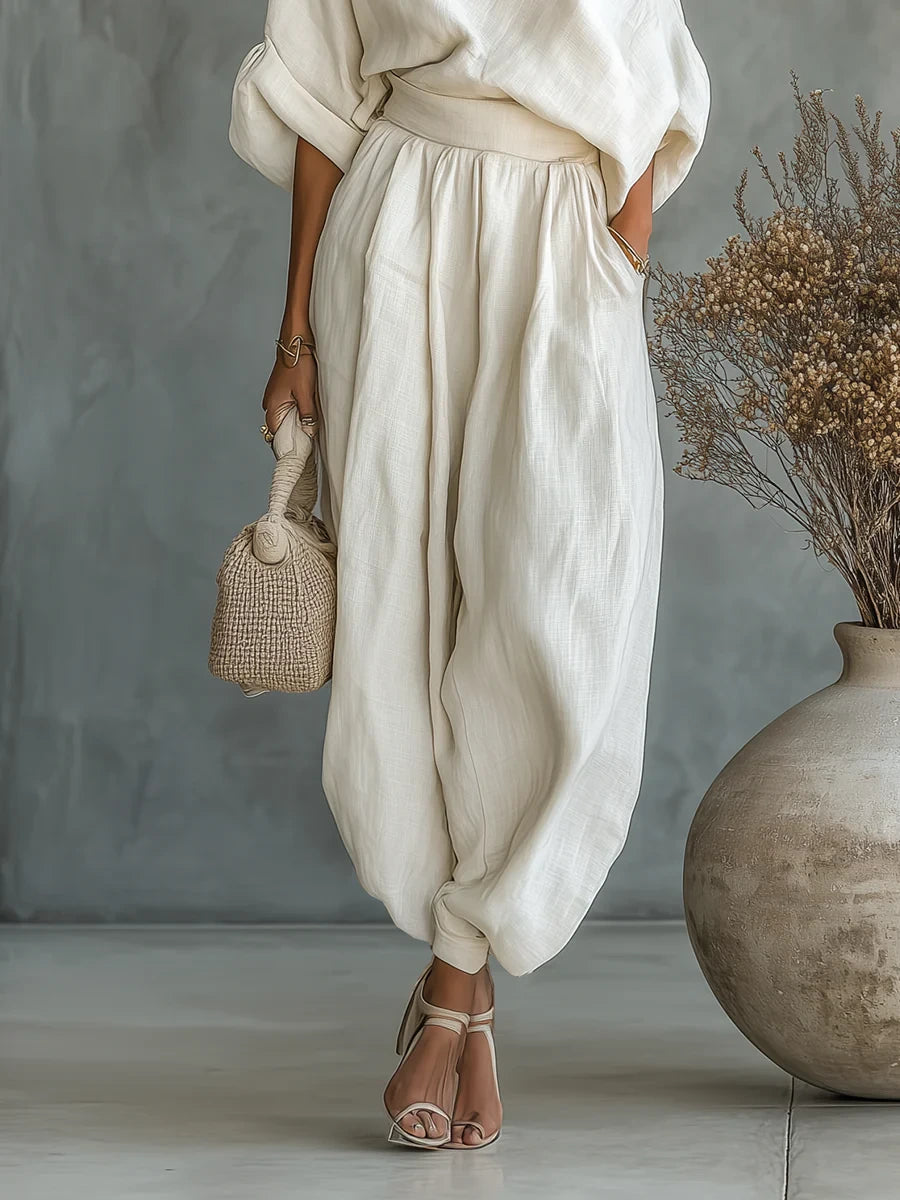 Woman wearing an off-white off-shoulder two-piece outfit, side view