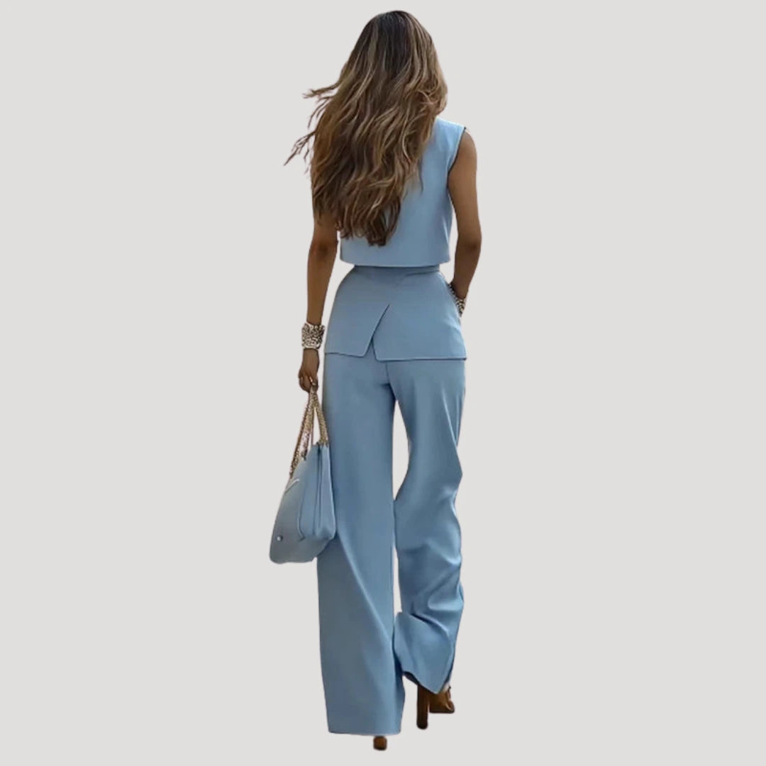 Woman wearing a light blue sleeveless blazer and wide-leg trouser set in a lifestyle setting