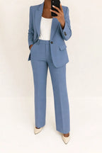 Woman wearing a blue wide-leg button-down blazer and trouser set in a studio setting