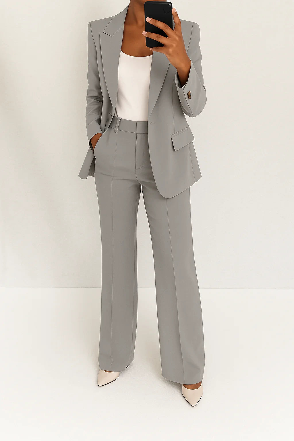 Woman wearing a grey wide-leg button-down blazer and trouser set in a studio setting