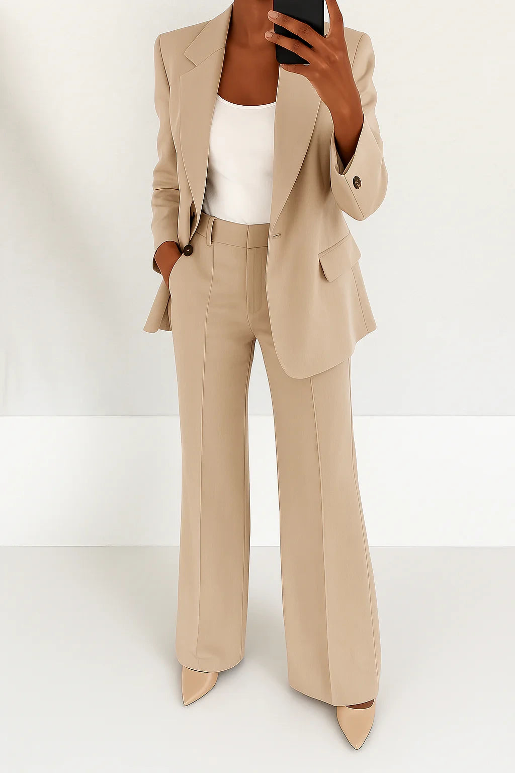 Woman wearing a beige wide-leg button-down blazer and trouser set in a studio setting