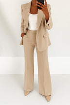 Woman wearing a beige wide-leg button-down blazer and trouser set in a studio setting