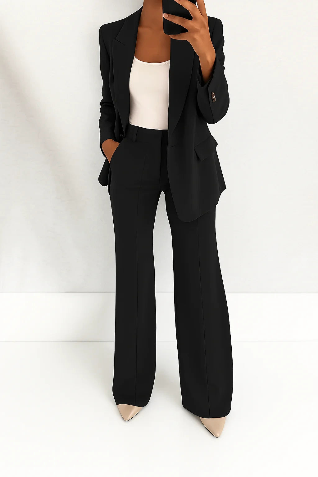 Woman wearing a black wide-leg button-down blazer and trouser set in a studio setting