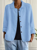Woman wearing a light blue collared button-front long sleeve blazer in a studio setting