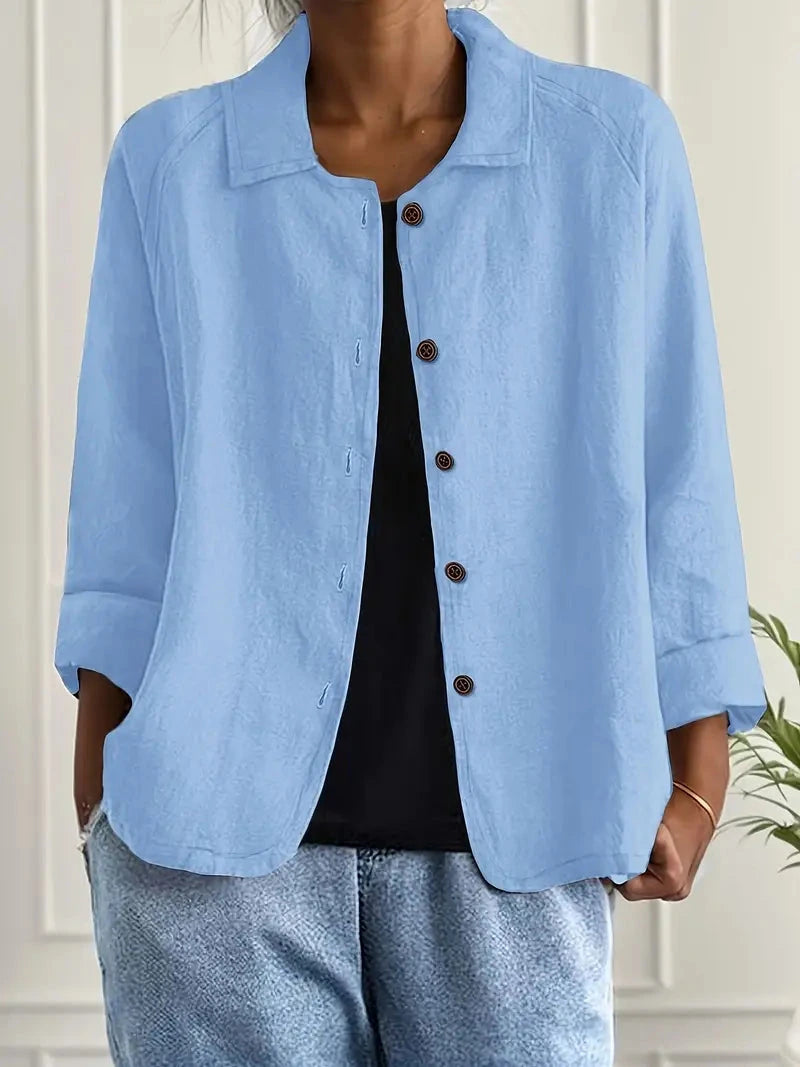 Woman wearing a light blue collared button-front long sleeve blazer in a studio setting