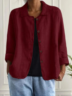 Woman wearing a burgundy collared button-front long sleeve blazer in a studio setting