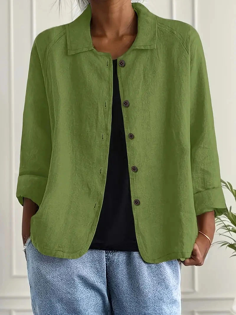 Woman wearing a green collared button-front long sleeve blazer in a studio setting