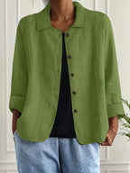 Woman wearing a green collared button-front long sleeve blazer in a studio setting
