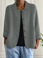 Woman wearing a light grey collared button-front long sleeve blazer, alternate shade in a studio setting