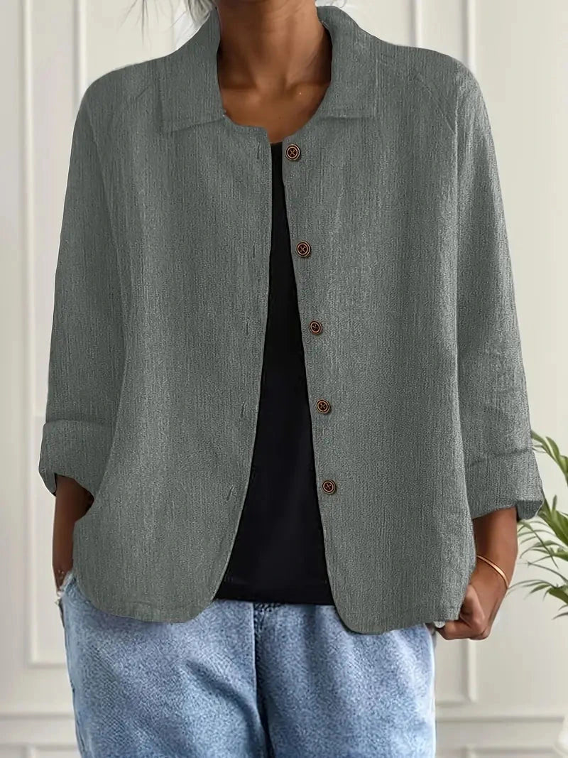Woman wearing a light grey collared button-front long sleeve blazer, alternate shade in a studio setting
