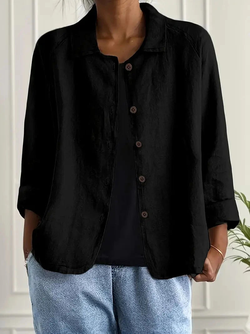 Woman wearing a black collared button-front long sleeve blazer in a studio setting