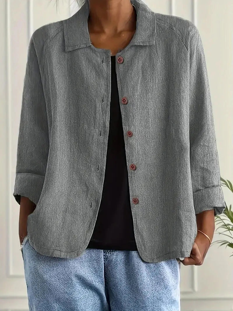 Woman wearing a grey collared button-front long sleeve blazer in a studio setting