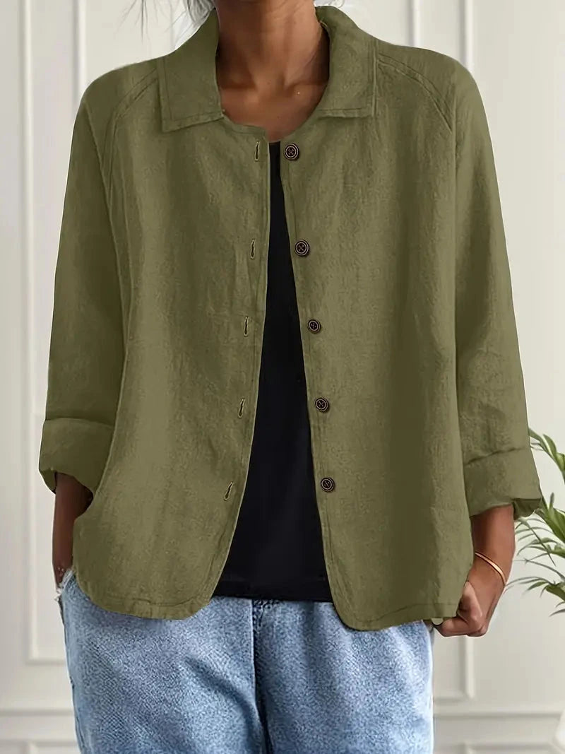 Woman wearing a dark green collared button-front long sleeve blazer in a studio setting