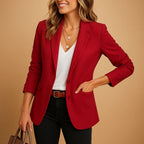 Woman wearing a burgundy one-button fitted blazer in a studio setting