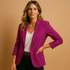 Woman wearing a purple one-button fitted blazer in a studio setting